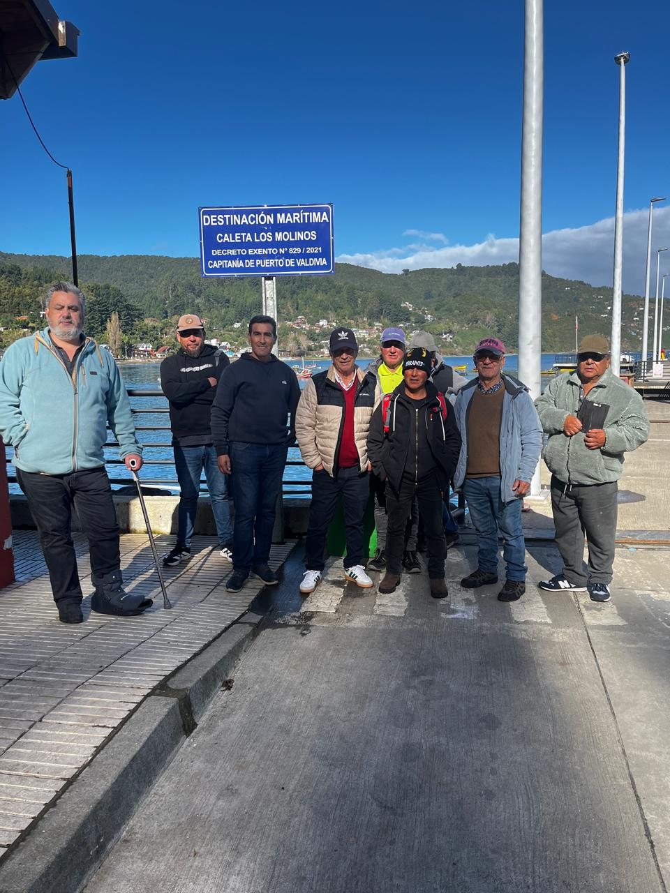 Participantes junto al letrero de destinación marítima de Caleta Los Molinos, Valdivia.